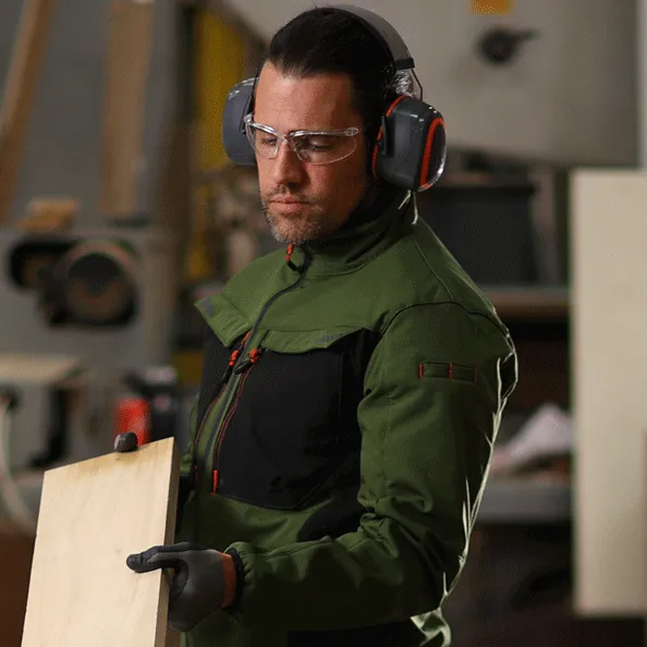 Pekerja di industri manufaktur menggunakan APD lengkap Portwest—kacamata, pelindung pendengaran, dan sarung tangan—untuk perlindungan diri menyeluruh.