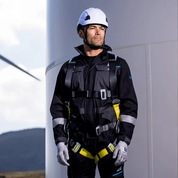 Pekerja industri minyak dan gas memakai coverall APD tahan api (Flame Resistant) Portwest dengan harness keselamatan, solusi dari Maduma Inti Teknik.